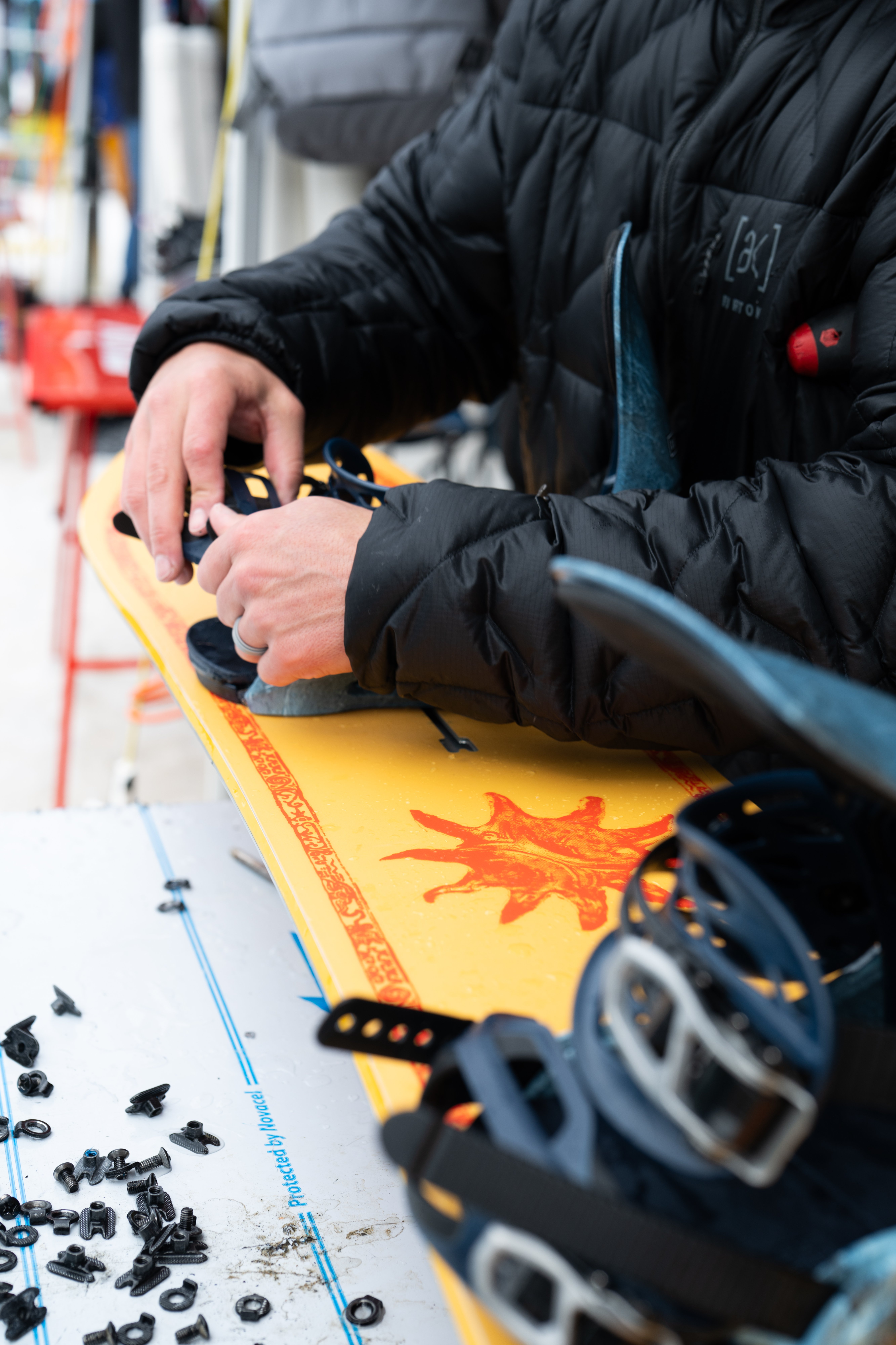 Alpine Ski Center technician mounting snowboard bindings